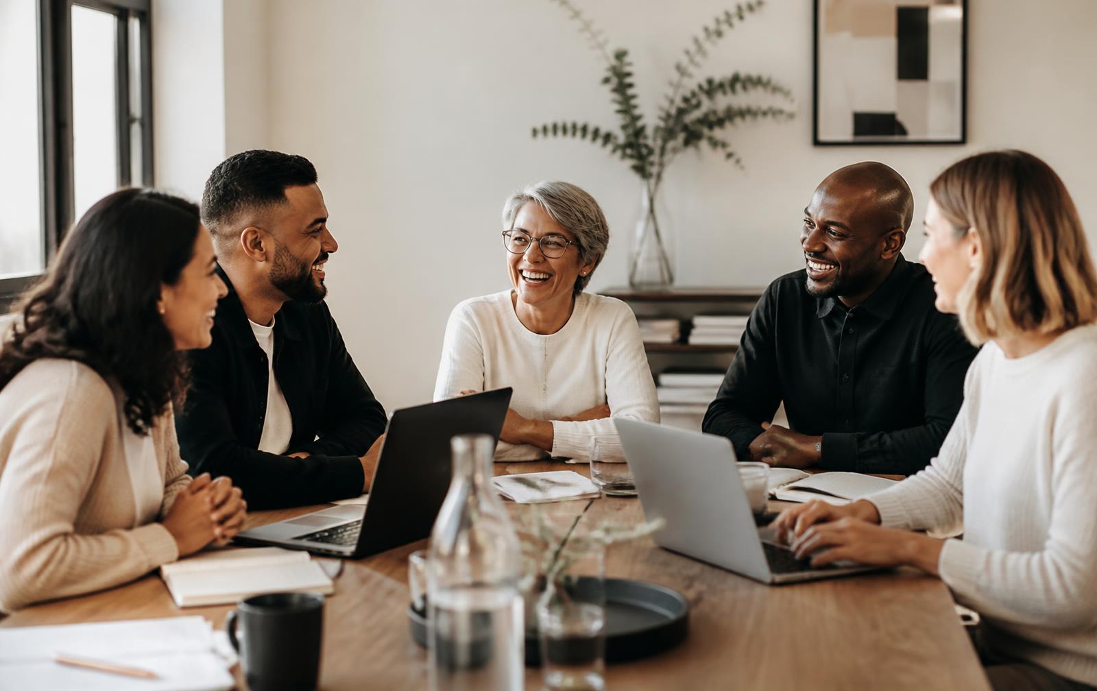 A small business team working together around a table, laughing during a planning session